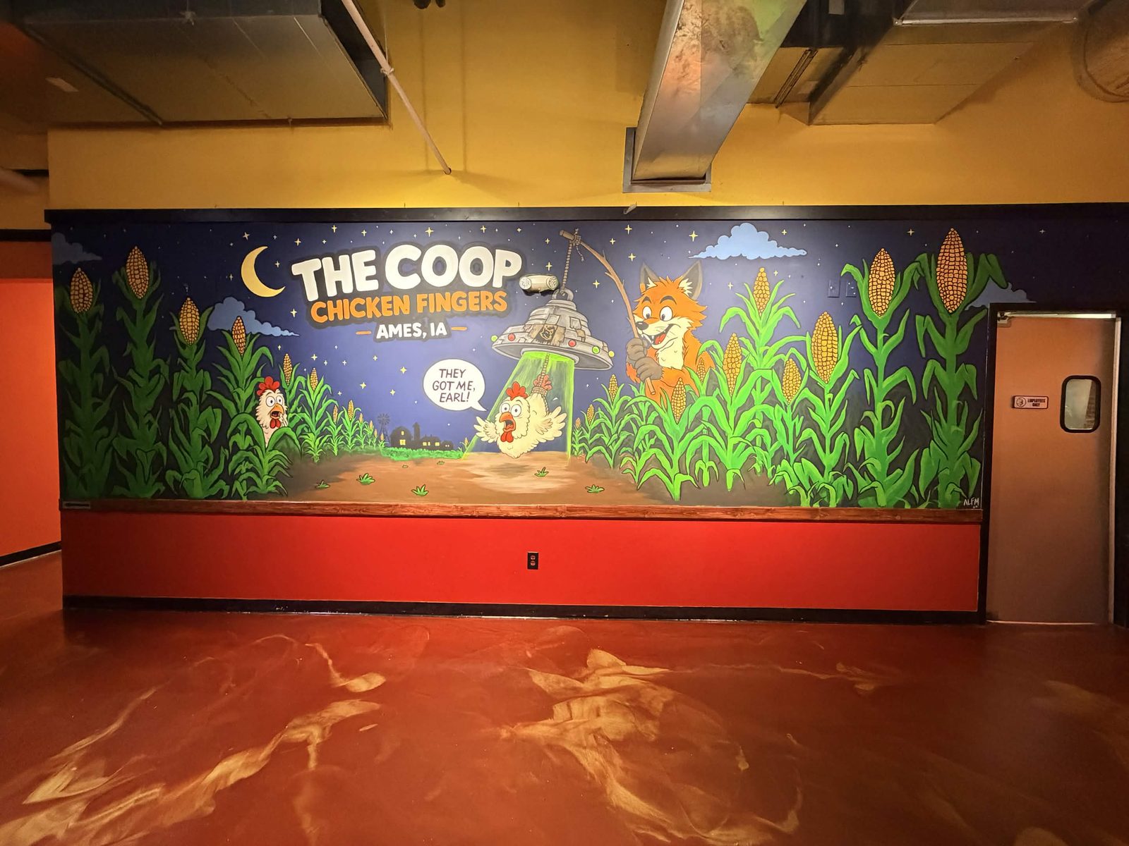 The full Coop Chicken Fingers mural wall inside the restaurant, with the painted fox, flying saucer and cornfield scene
