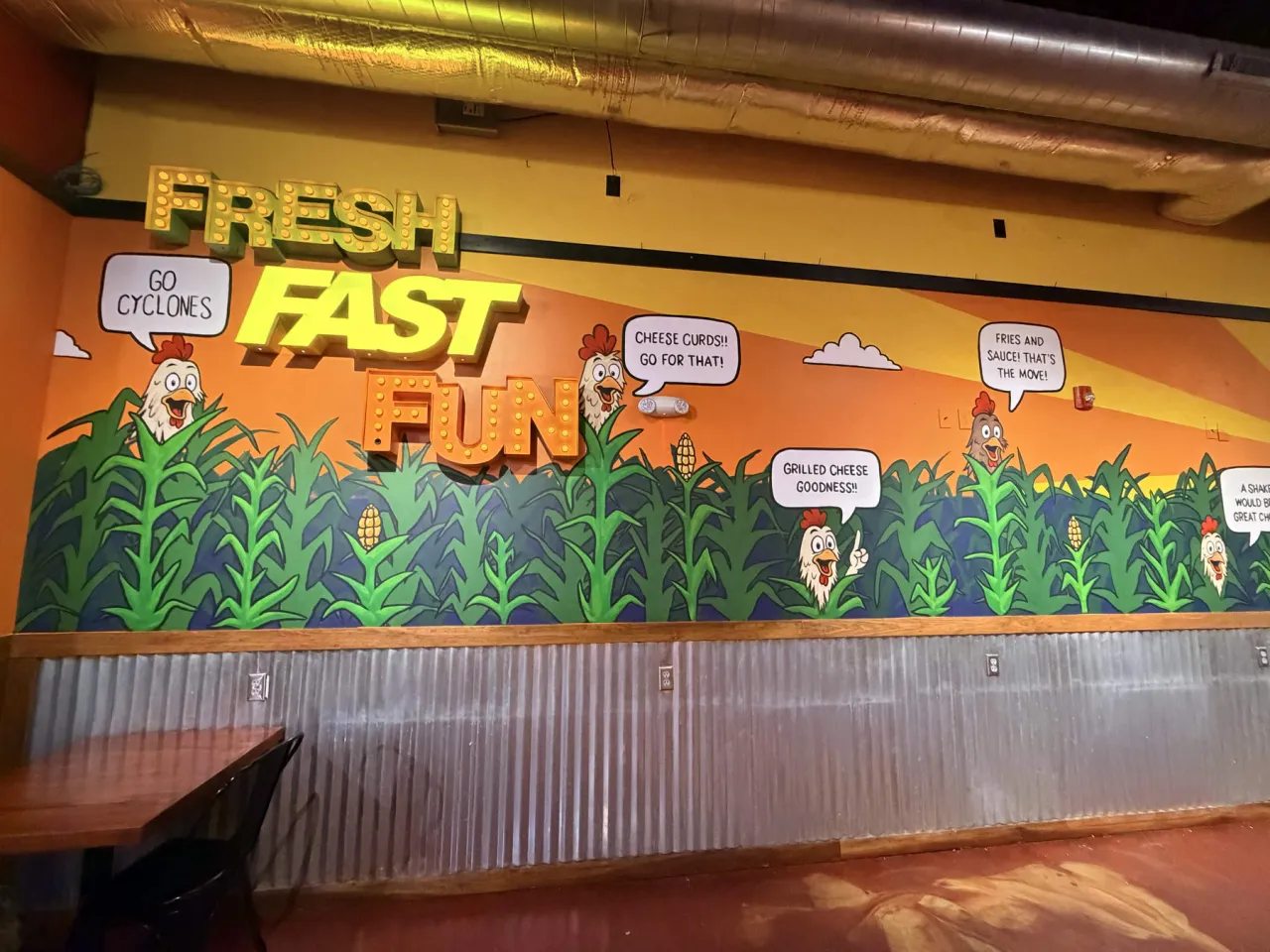 The left section of the second Coop wall showing the FRESH, FAST and FUN marquee letters above painted chickens and speech bubbles