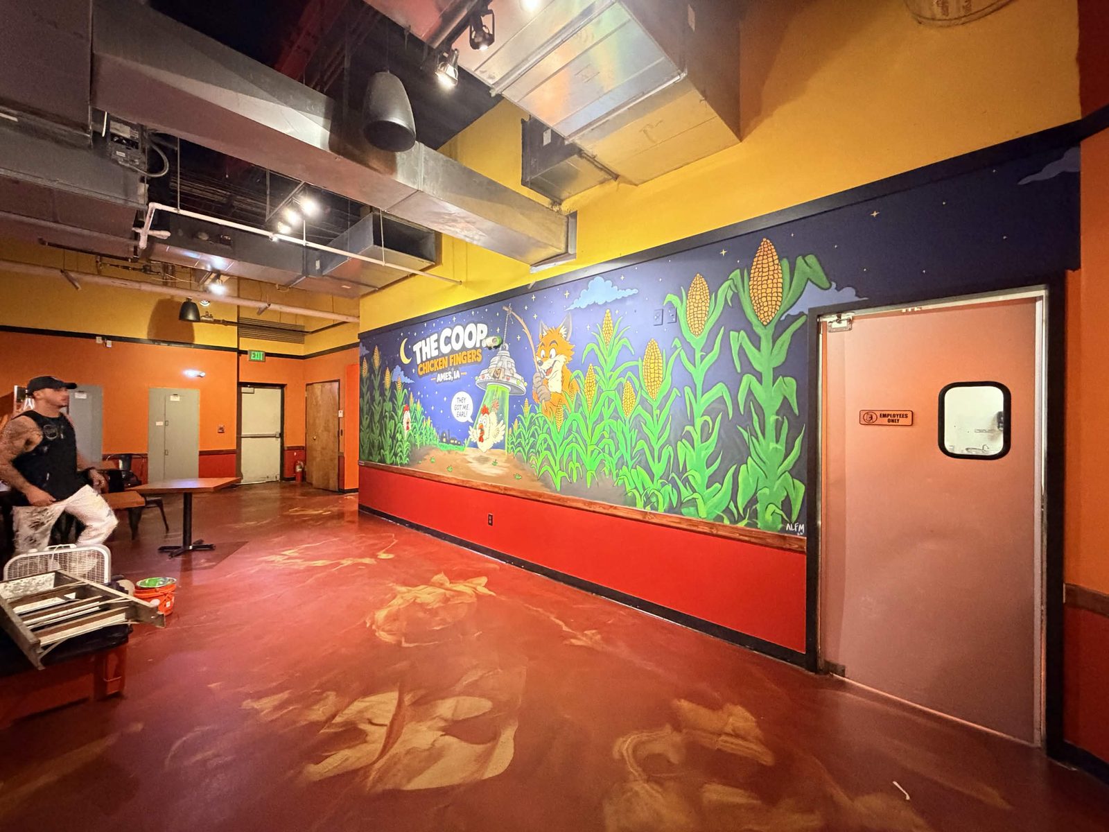 The Coop Chicken Fingers mural wall seen at an angle along the dining room